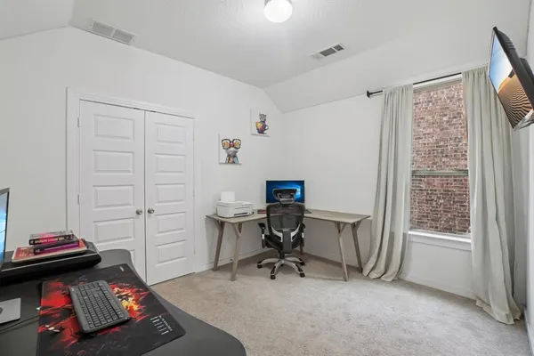 a view of a workspace with furniture and a window