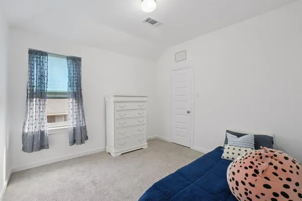 a view of a bedroom with furniture and wooden floor