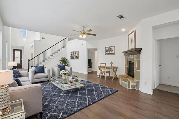 a living room with furniture a fireplace and wooden floor