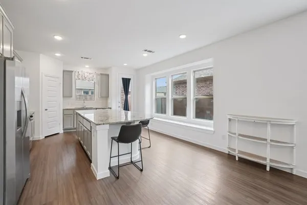 a view of a kitchen with furniture and wooden floor