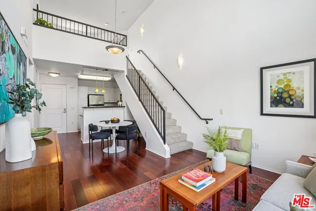a living room with furniture and a dining table with wooden floor