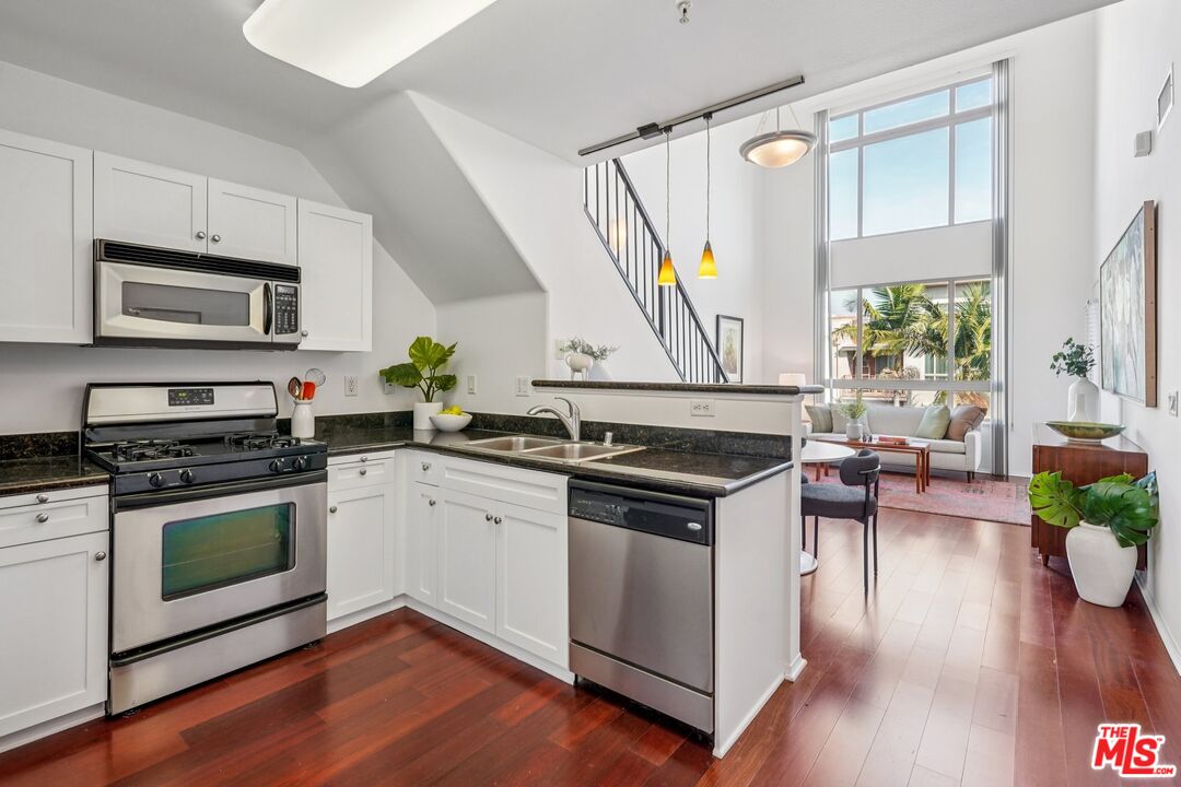 100 South Alameda Street, Unit 477 Los Angeles, CA 90012 - Photo 4 of 24 a kitchen with a stove a sink and a microwave