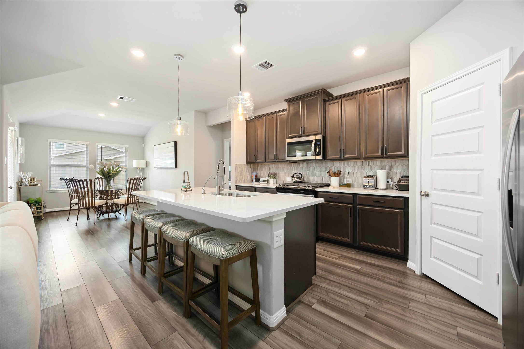 6910 Lebec Drive Rosharon, TX 77583 - Photo 11 of 26 a kitchen with kitchen island granite countertop wooden floors and wooden cabinets