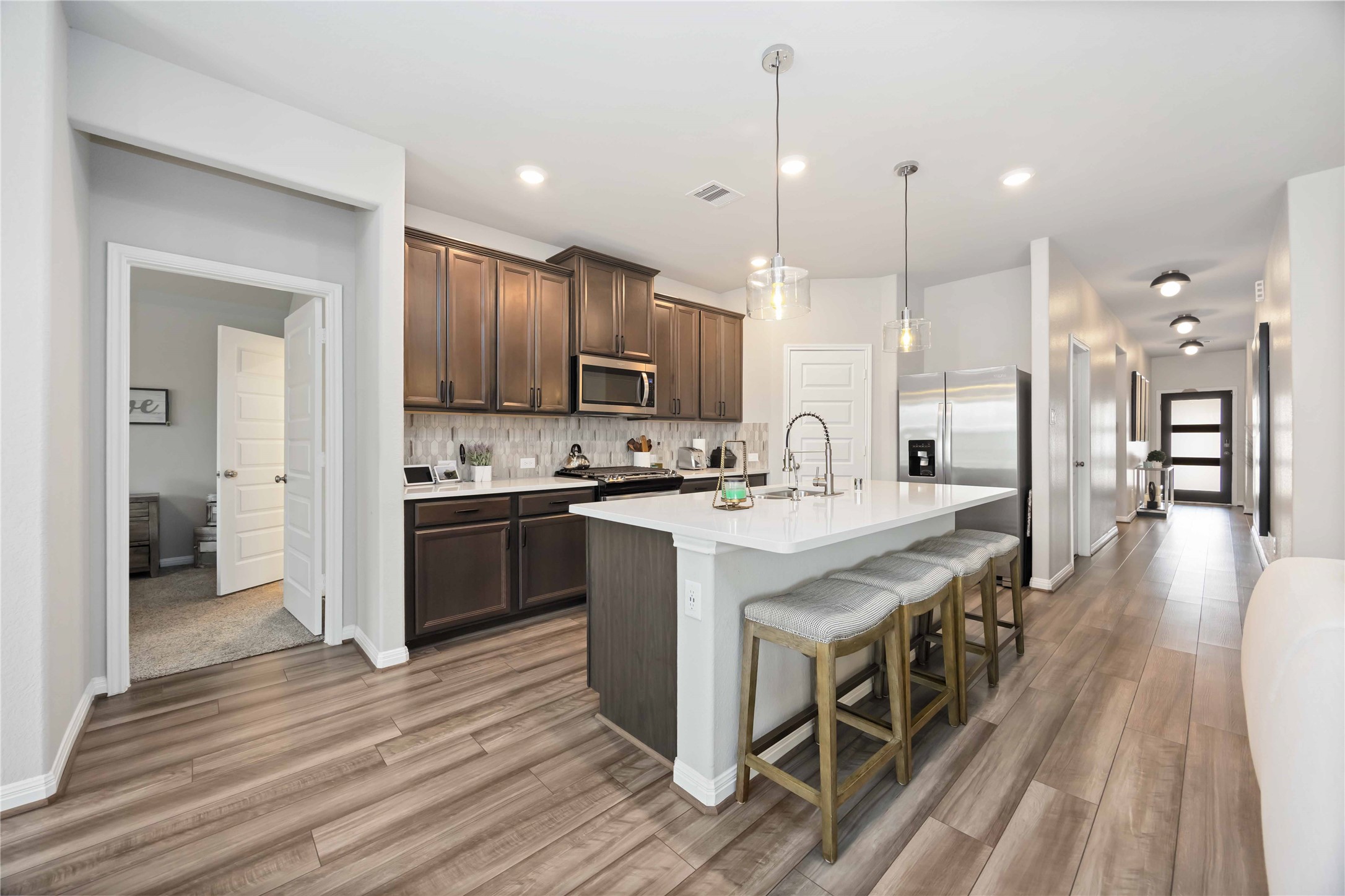 6910 Lebec Drive Rosharon, TX 77583 - Photo 12 of 26 a kitchen with stainless steel appliances kitchen island granite countertop a large stove a sink dishwasher and a refrigerator with wooden floor