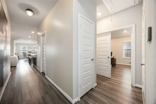 a view of a hallway view with wooden floor and living room