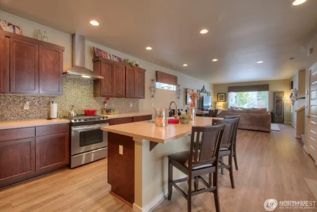 a kitchen with kitchen island granite countertop wooden floors and wooden cabinets