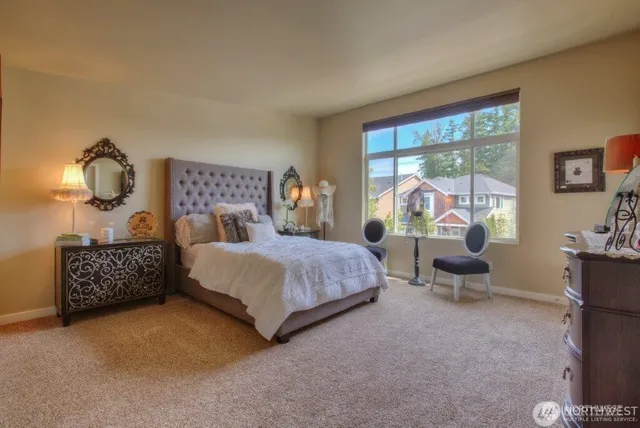a bedroom with a bed and large windows
