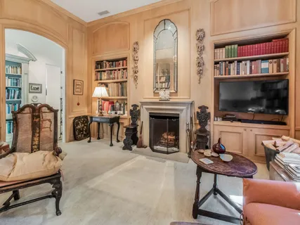 a living room with furniture fireplace and baby crib