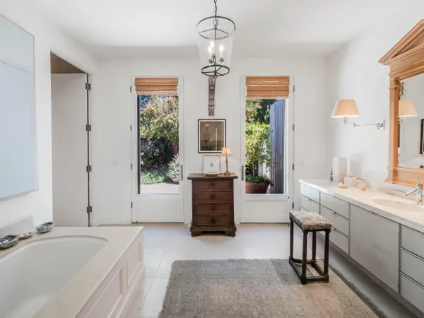 a bedroom with a bed chandelier and a window