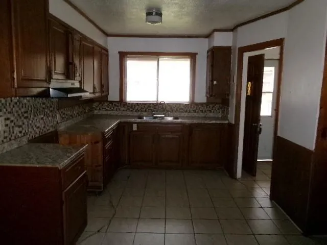 a kitchen with a sink stove and cabinets