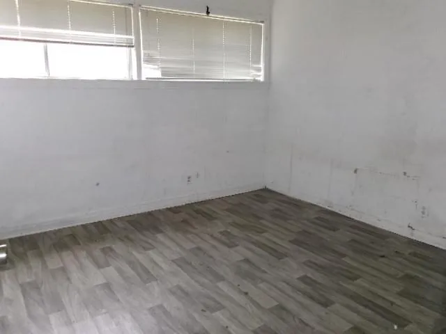 a view of a room that has wooden floor and windows