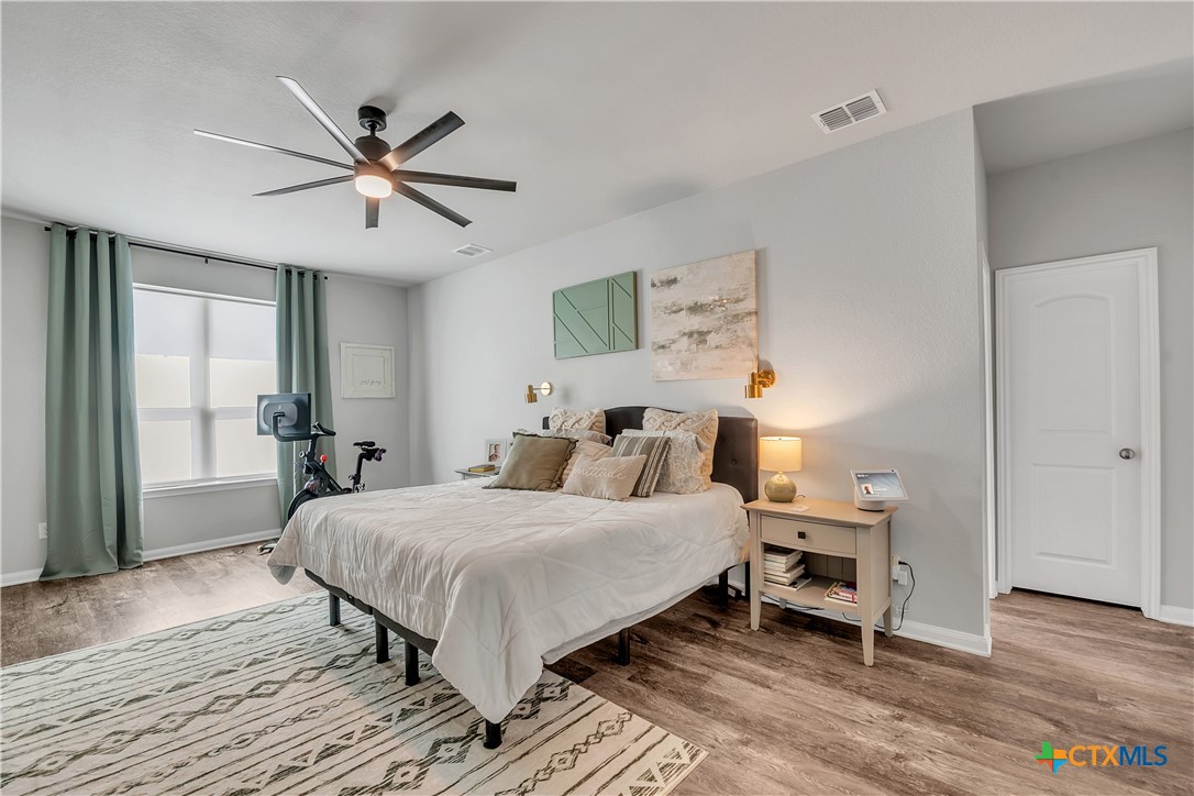 5010 Fallen Tree Drive Temple, TX 76502 - Photo 12 of 40 a bedroom with a bed and wooden floor