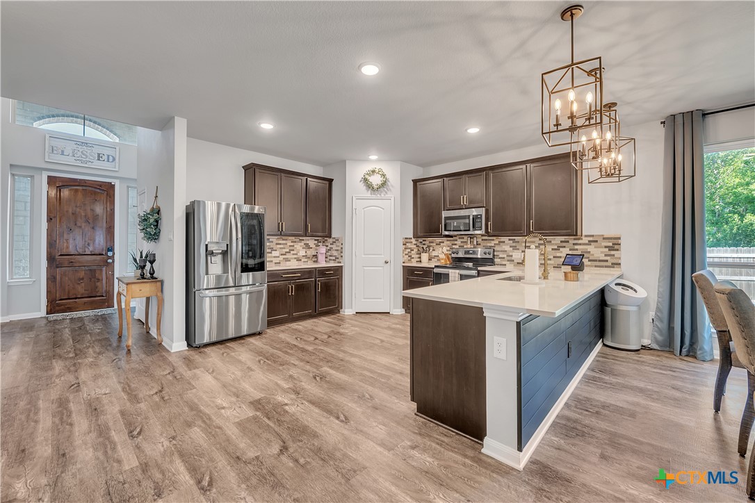 5010 Fallen Tree Drive Temple, TX 76502 - Photo 7 of 39 a large kitchen with stainless steel appliances kitchen island granite countertop a large counter top and wooden floors