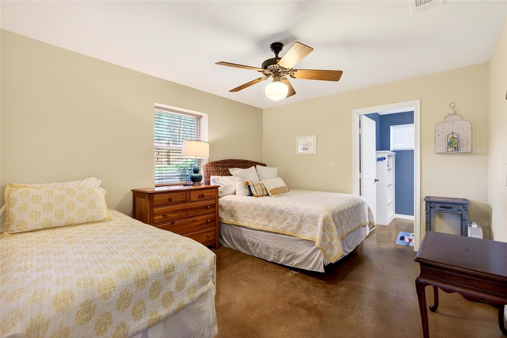 1113 Rim O The World Drive Tool, TX 75143 - Photo 25 of 40 Cabin Bedroom #2 featuring a ceiling fan with integrated lighting, a window with blinds, and durable stained concrete flooring, and ensuite half bath.