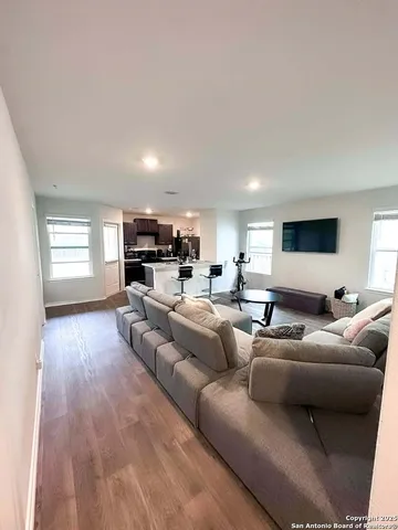 a living room with furniture and a wooden floor