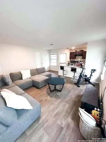 a living room with furniture and a wooden floor