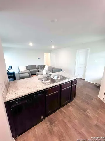 a kitchen with a sink and a wooden floor