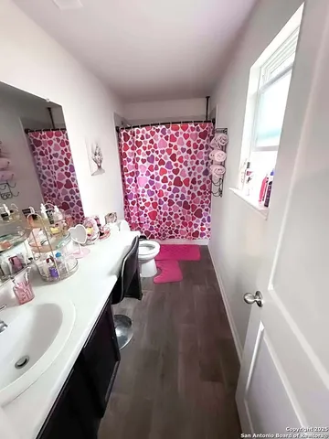 a bathroom with a sink vanity mirror and toilet