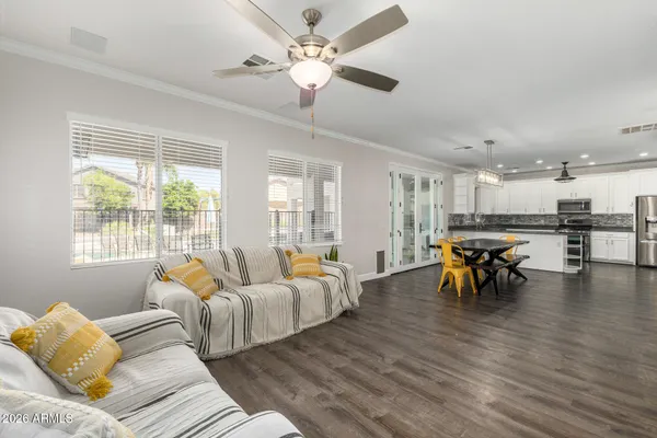 a kitchen with stainless steel appliances kitchen island granite countertop a stove top oven a sink dishwasher a dining table and chairs with wooden floor