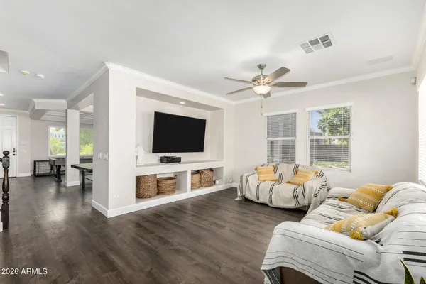 a large white kitchen with granite countertop a stove a sink a dining table and chairs with wooden floor