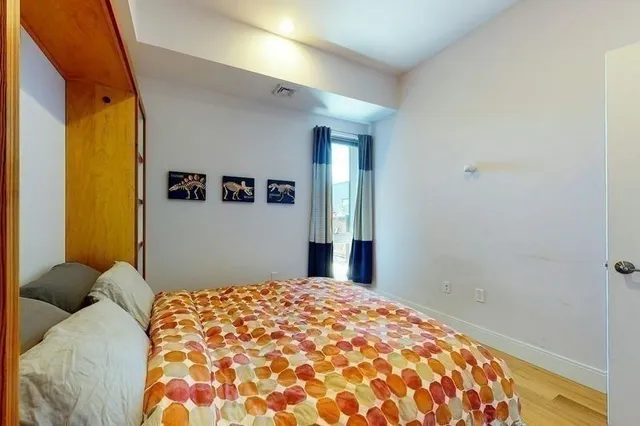 a bedroom with a bed and a painting on the wall