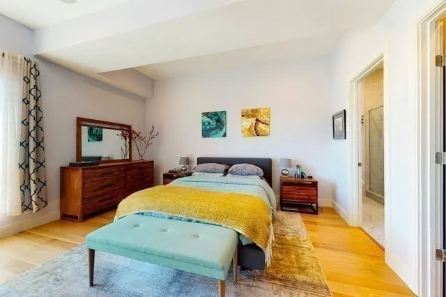 a bedroom with bed and wooden floor