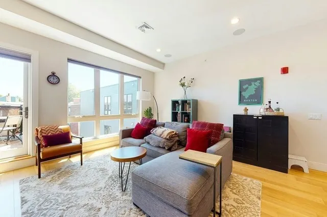 a living room with furniture potted plant and a large window