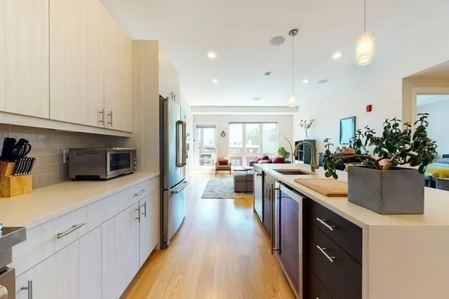 a kitchen with stainless steel appliances kitchen island granite countertop a sink a stove top oven a counter space and cabinets