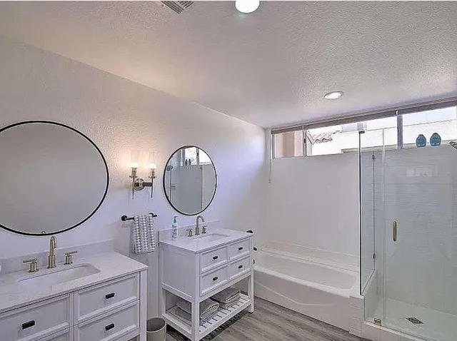 a bathroom with a sink mirror vanity and a bathtub