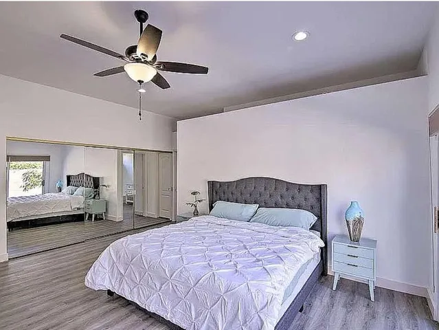 a bedroom with a bed and wooden floor