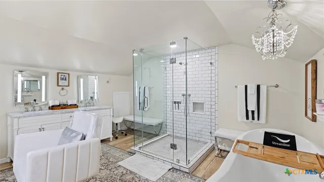 a bathroom with a tub shower sink and mirror