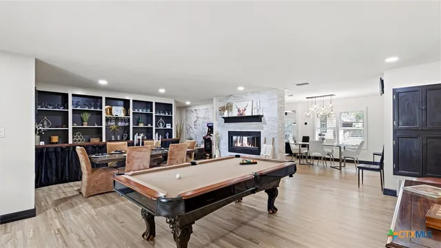 a living room with stainless steel appliances furniture a table and a kitchen view