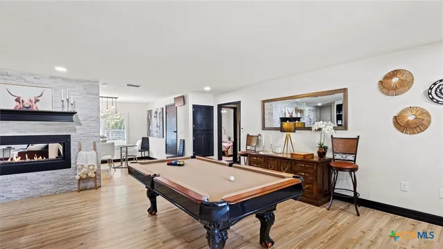 a living room with furniture pool table and a fireplace
