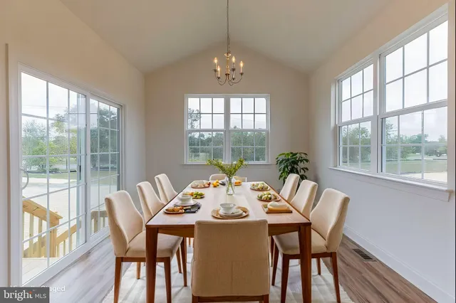 a dining room with furniture large windows and wooden floor
