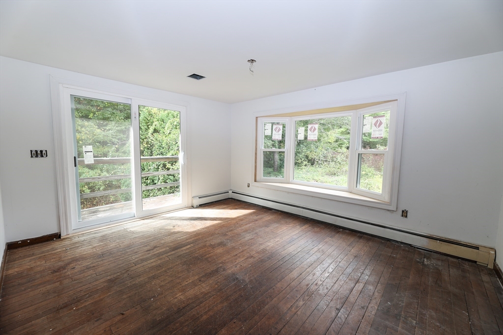 329 Woodside Road Barnstable, MA 02668 - Photo 4 of 26 a view of an empty room with wooden floor and a window