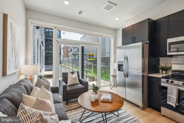 a living room with furniture a large window and a table