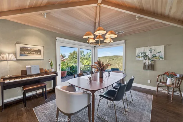 a kitchen with stainless steel appliances granite countertop a stove top oven a sink dishwasher a dining table and chairs with wooden floor