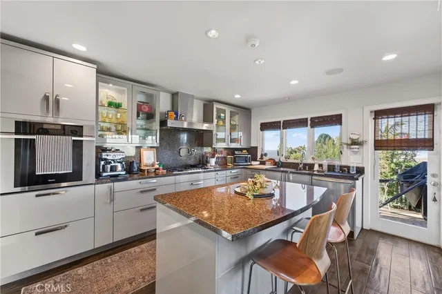a kitchen with stainless steel appliances kitchen island granite countertop a sink and cabinets