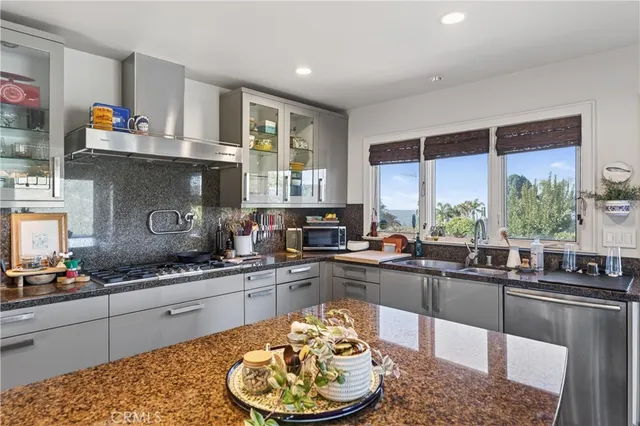 a kitchen with stainless steel appliances granite countertop a sink stove and cabinets