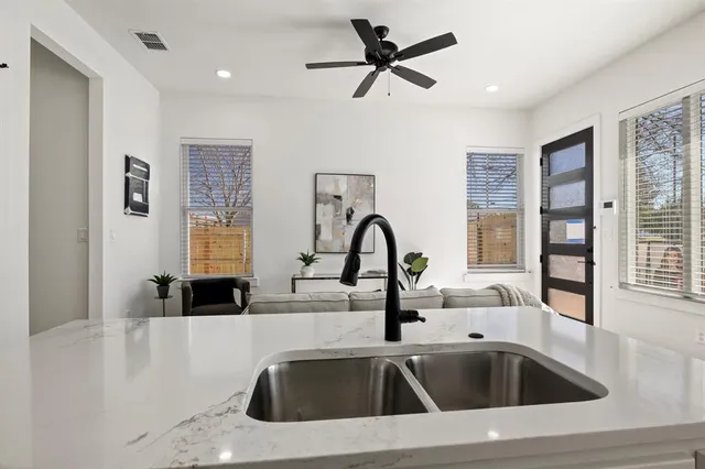 a kitchen with granite countertop white cabinets and stainless steel appliances