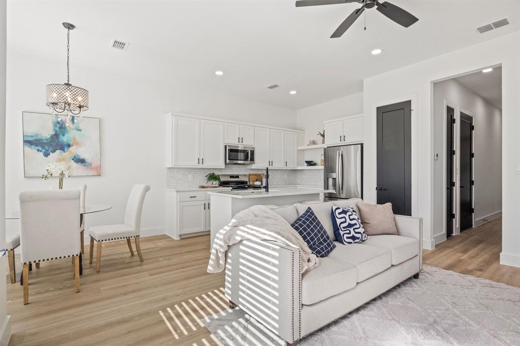 196 West 17th Street Mount Pleasant, TX 75455 - Photo 6 of 35 a living room with white couches and kitchen view with wooden floor