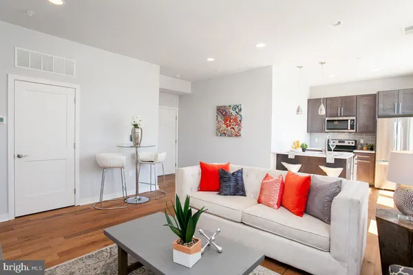 a living room with furniture and a kitchen view