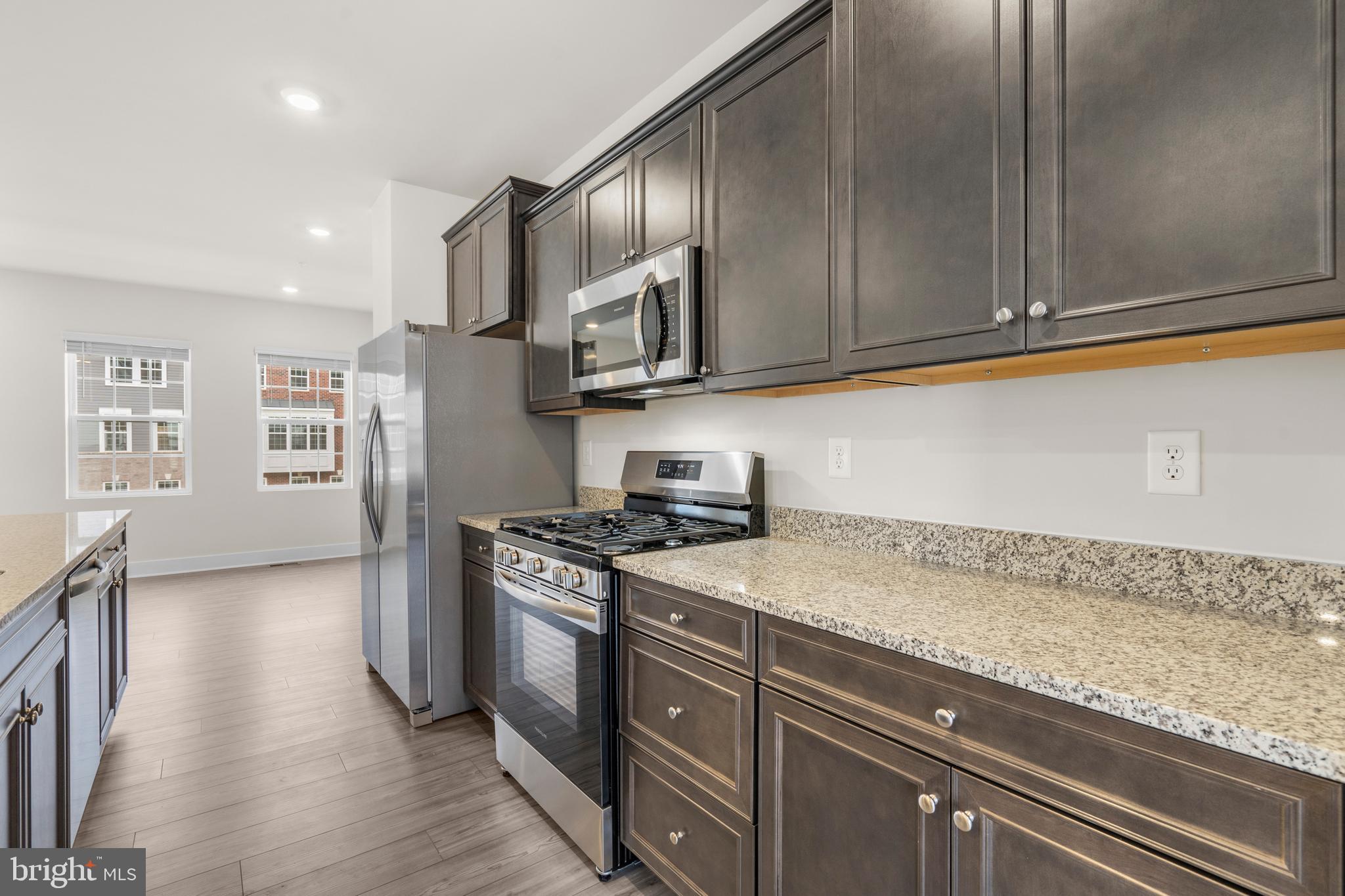 1826 Parham Way Windsor Mill, MD 21244 - Photo 10 of 37 a kitchen with stainless steel appliances granite countertop a refrigerator a sink dishwasher a stove and white cabinets with wooden floor