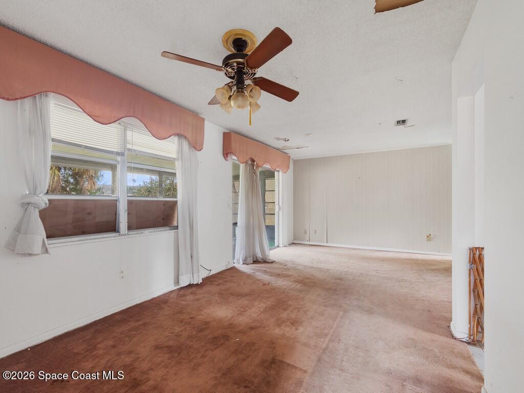 1076 Madrid Road Rockledge, FL 32955 - Photo 11 of 30 a view of a big room with a ceiling fan