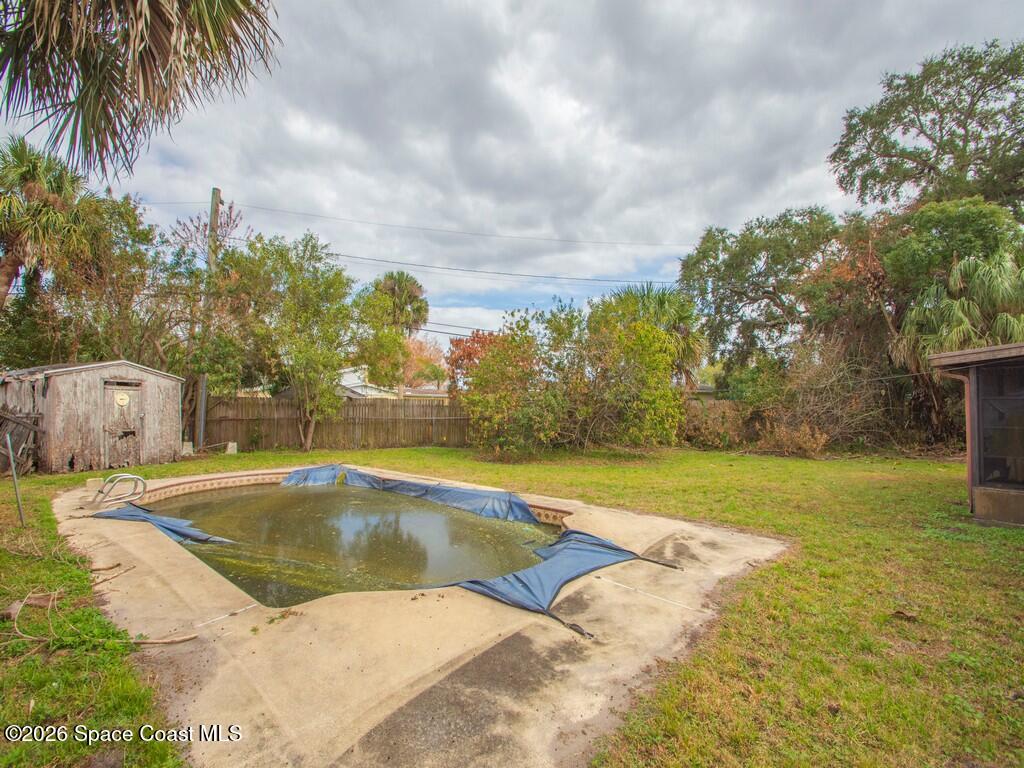 1076 Madrid Road Rockledge, FL 32955 - Photo 25 of 30 a view of swimming pool with a yard and palm trees