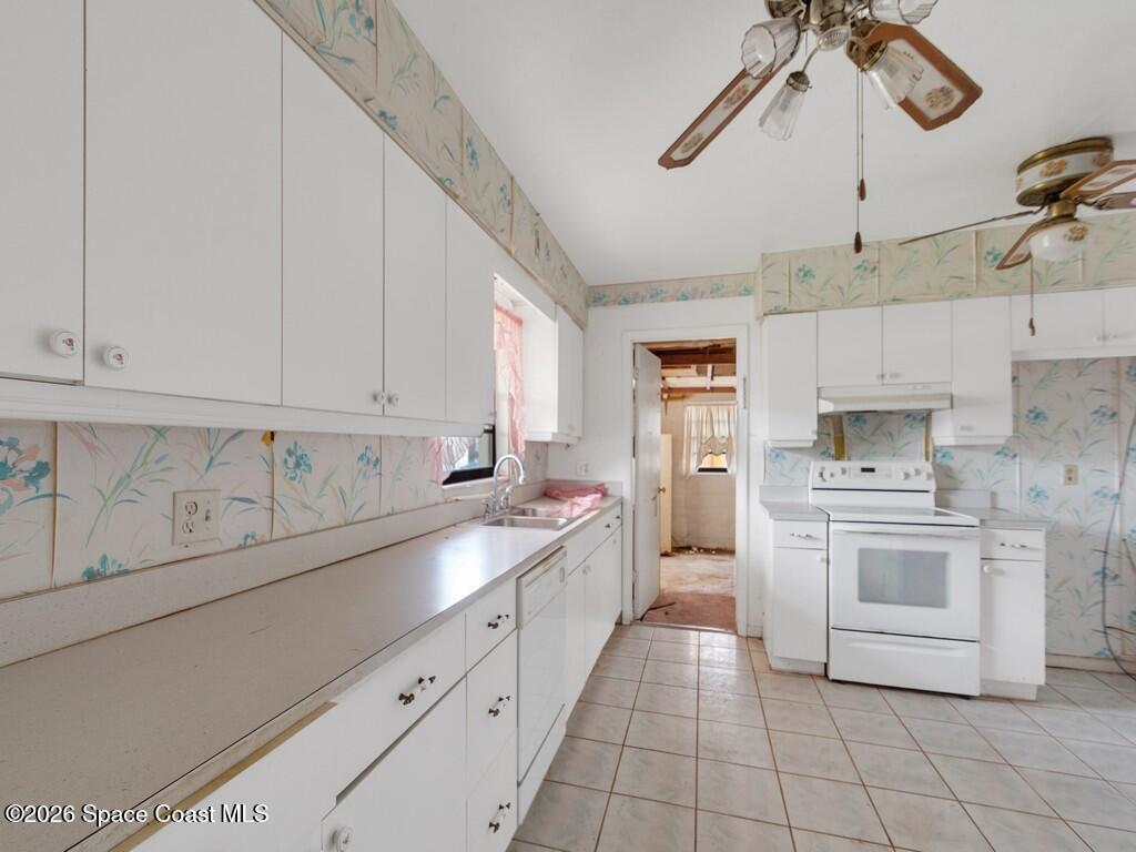 1076 Madrid Road Rockledge, FL 32955 - Photo 2 of 30 a large kitchen with cabinets a sink and white appliances