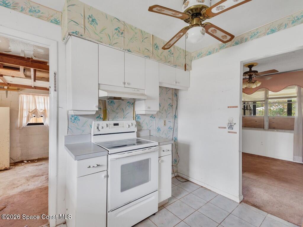 1076 Madrid Road Rockledge, FL 32955 - Photo 3 of 30 a kitchen with stainless steel appliances white cabinets and white appliances
