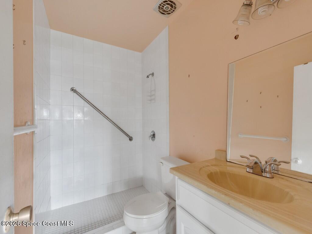 1076 Madrid Road Rockledge, FL 32955 - Photo 6 of 30 a bathroom with a sink a toilet and shower