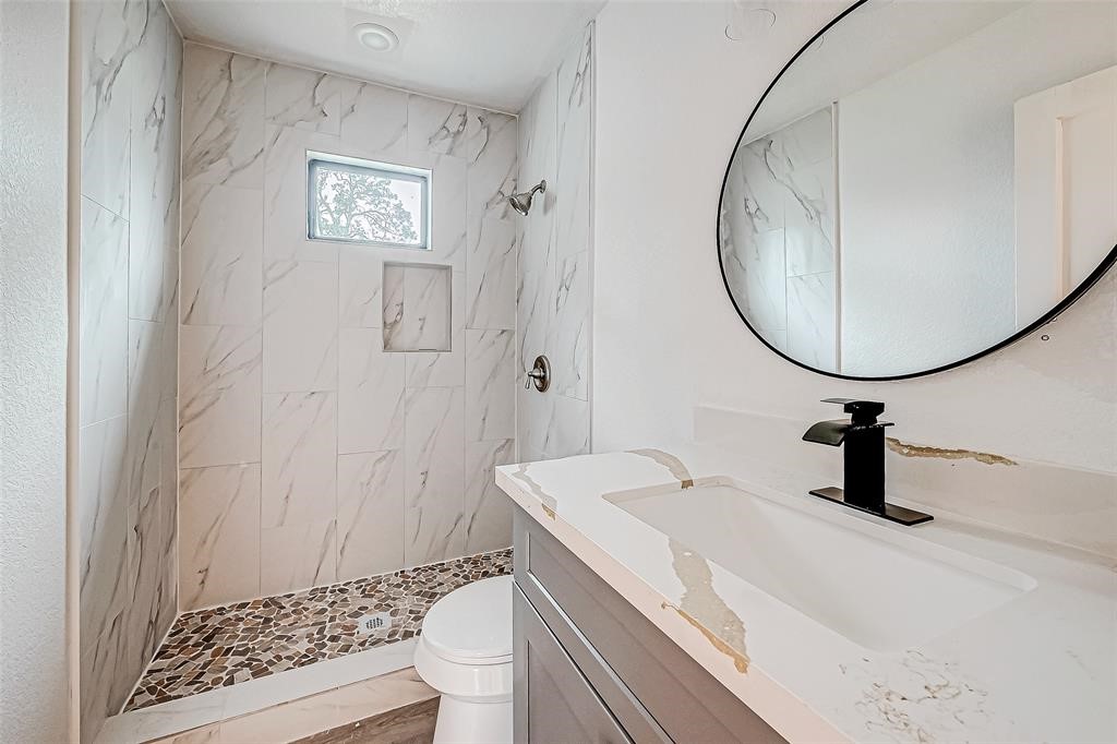 7010 South Hall Street Houston, TX 77028 - Photo 22 of 33 a bathroom with a sink a toilet and a mirror