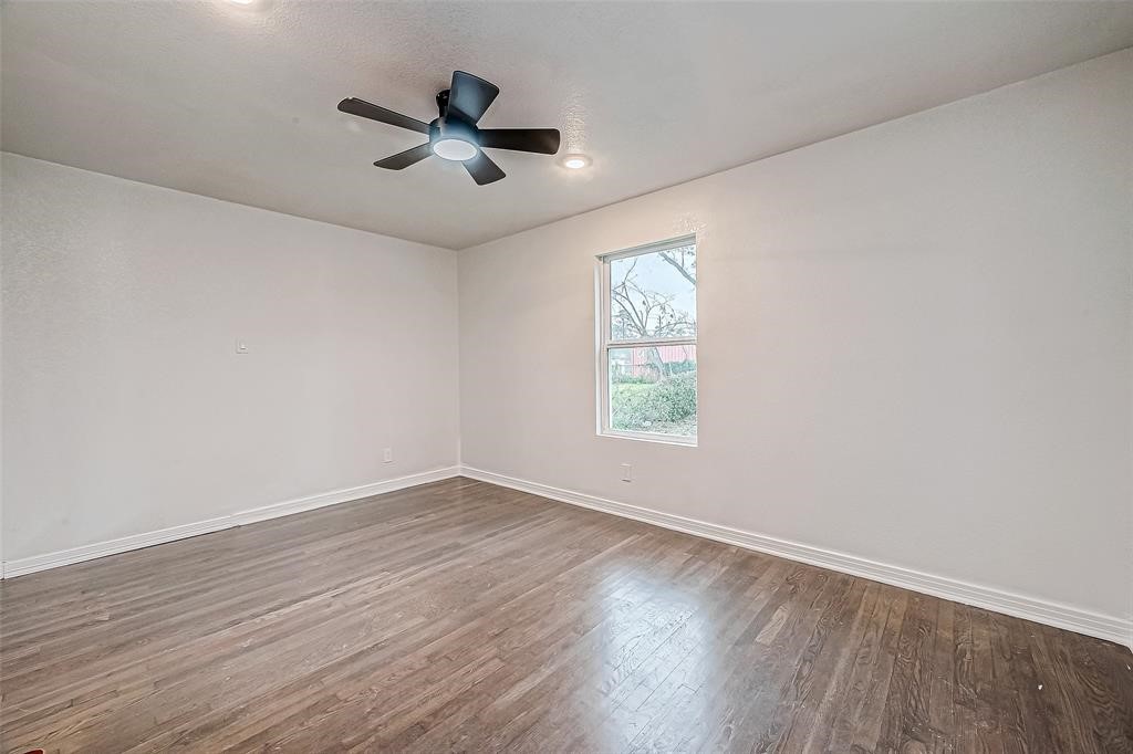 7010 South Hall Street Houston, TX 77028 - Photo 28 of 33 an empty room with wooden floor ceiling fan and windows